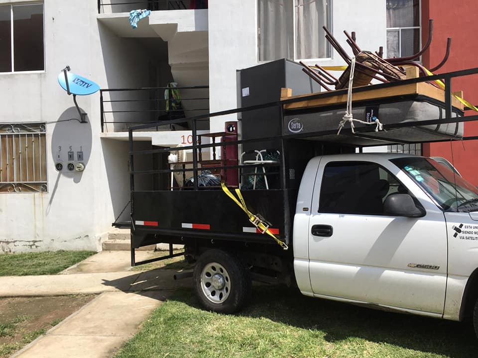 Muebles y sillas amarrados en la caja de una camioneta
