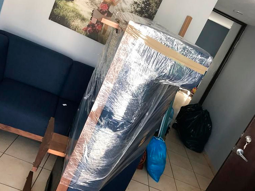 Sofá envuelto en plástico dentro del domicilio antes de salir