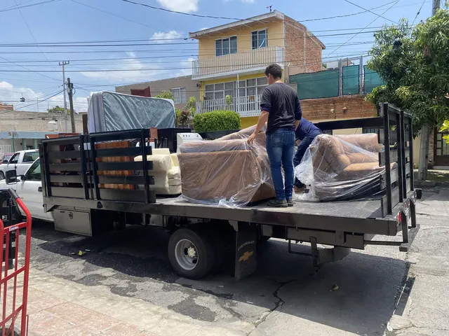 Muebles envueltos en plástico cargados en el camión durante una mudanza