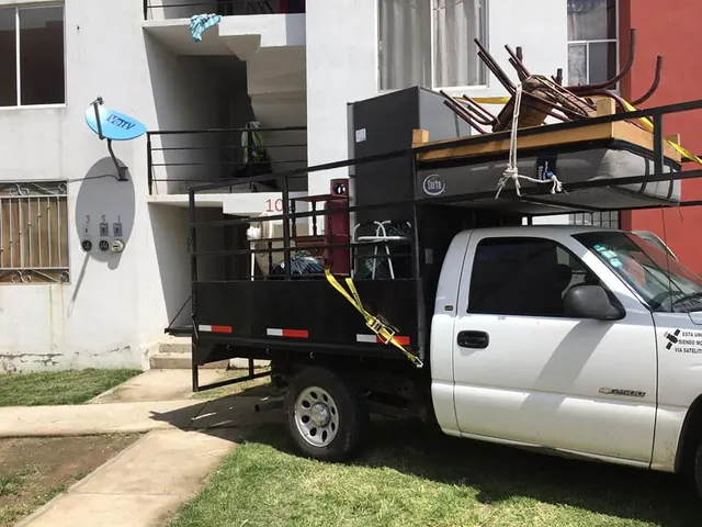 Muebles y sillas amarrados en la caja de una camioneta